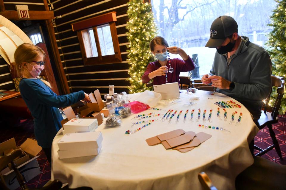 Myley, Bella and Steve Moorefield gather to create suncatchers Dec. 2 in Waite Park, Minn.