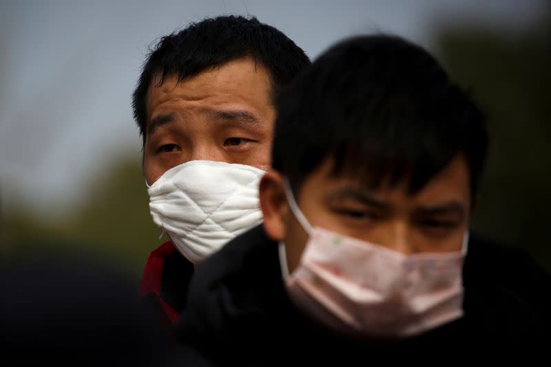 FILE PHOTO: People coming from the Hubei province wait at a checkpoint at the Jiujiang Yangtze River Bridge in Jiujiang