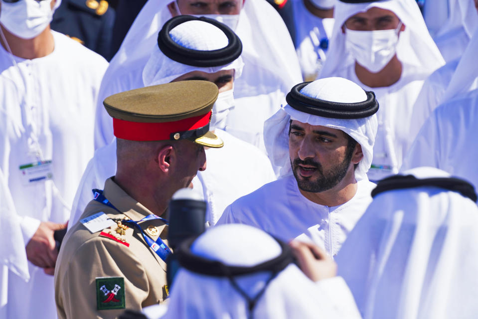 Sheikh Hamdan bin Mohammed Al Maktoum, the crown prince of Dubai, speaks to an Emirati soldier at the Dubai Air Show in Dubai, United Arab Emirates, Sunday, Nov. 14, 2021. The biennial Dubai Air Show opened Sunday as commercial aviation tries to shake off the coronavirus pandemic. (AP Photo/Jon Gambrell)