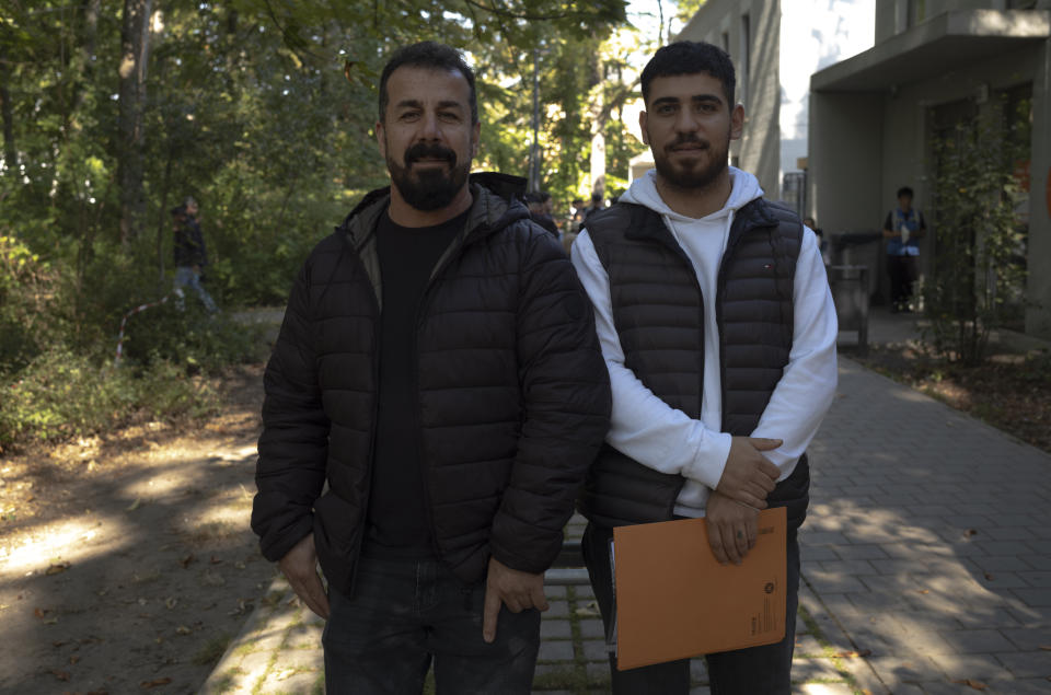 Mirbeycan Gurhan, right, and his uncle Sonar Gurhan pose for a photo after an interview with The Associated Press at the central registration for asylum seekers in Berlin, Germany, Monday, Sept. 25, 2023. Mirbeycan Gurhan, a young Kurdish man said he'd fled suppression by Turkish authorities and paid 6,000 euros, so that smugglers would arrange a flight from Ankara to Belgrade in Serbia, and from there take him by car to Germany. His Uncle applied for asylum four years ago and stood by and translated for him. (AP Photo/Markus Schreiber)