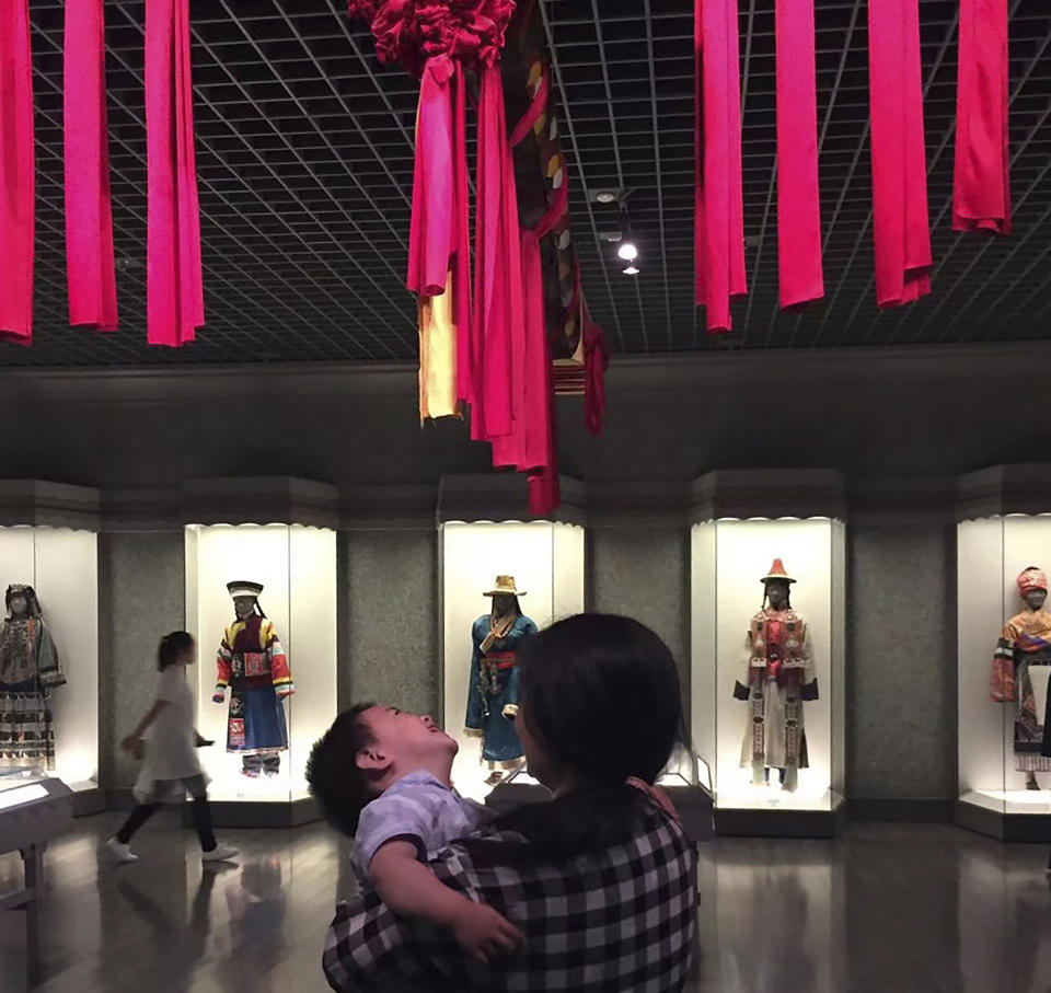 In this photo released by Zou Xiaoqi, Zou Xiaoqi, a single mother turned activist, holds her son during a visit to a museum in Shanghai in June, 2019. Zou, who has become a source of support for single moms ever since she started publicly campaigning for her maternity benefits, said that the cultural stigma around being a single mother is still very intense. (Zou Xiaoqi via AP)
