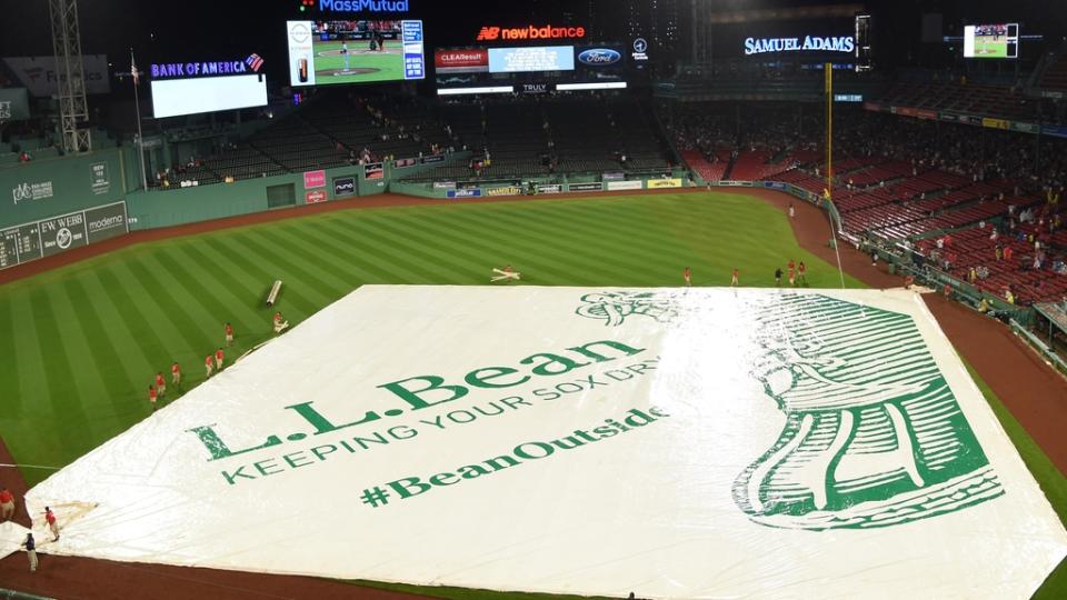 The Boston Red Sox grounds crew puts the tarp on the field during the fourth inning against the New York Mets at Fenway Park