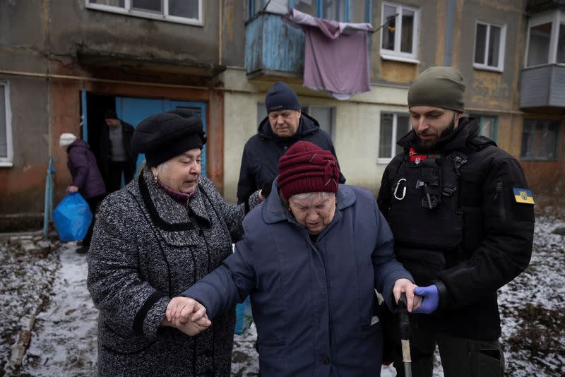 Volunteers of the East SOS non-governmental organisation evacuate Valentina Kitush from her home in Selydove