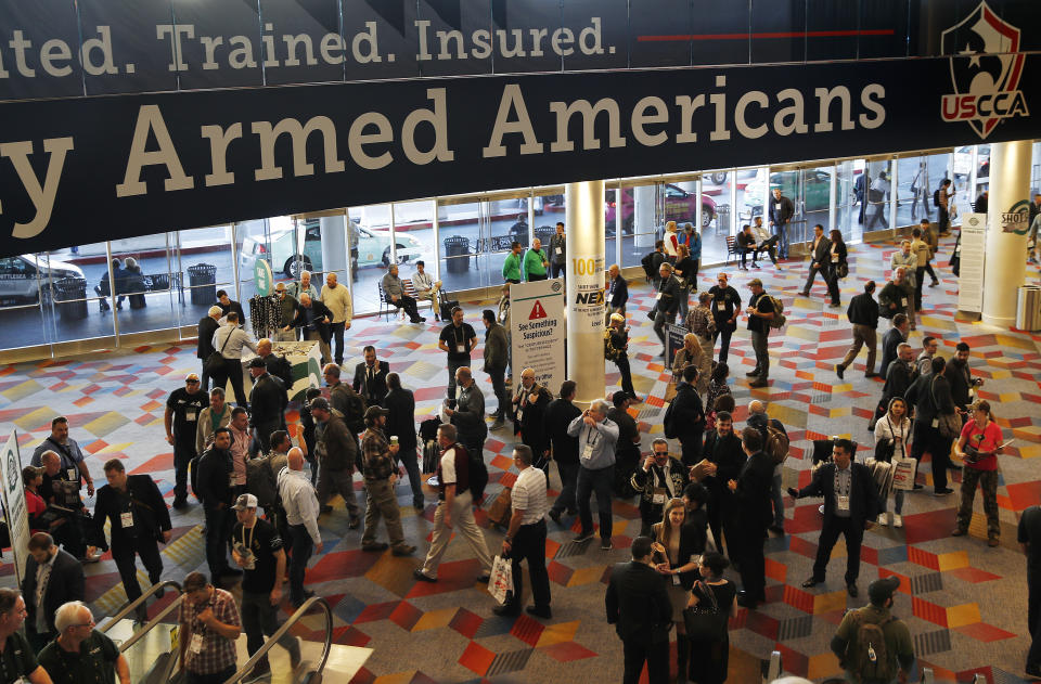 FILE - In this Wednesday, Jan. 24, 2018, file photo, people walk through the hall outside of the SHOT Show gun show in Las Vegas. The gun industry is gathering for its annual conference, in January 2020, amid a host of uncertainty: slumping gun sales, a public increasingly agitating for restrictions on access to firearms and a presidential campaign that threatens gun rights like perhaps no other time in modern American history. (AP Photo/John Locher, File)