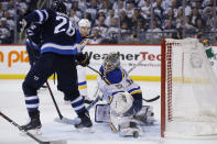 St. Louis Blues goaltender Jordan Binnington (50) saves the shot as Winnipeg Jets' Blake Wheeler (26) looks for the rebound during the second period of Game 5 of an NHL hockey first-round playoff series Thursday, April 18, 2019, in Winnipeg, Manitoba. (John Woods/The Canadian Press via AP)