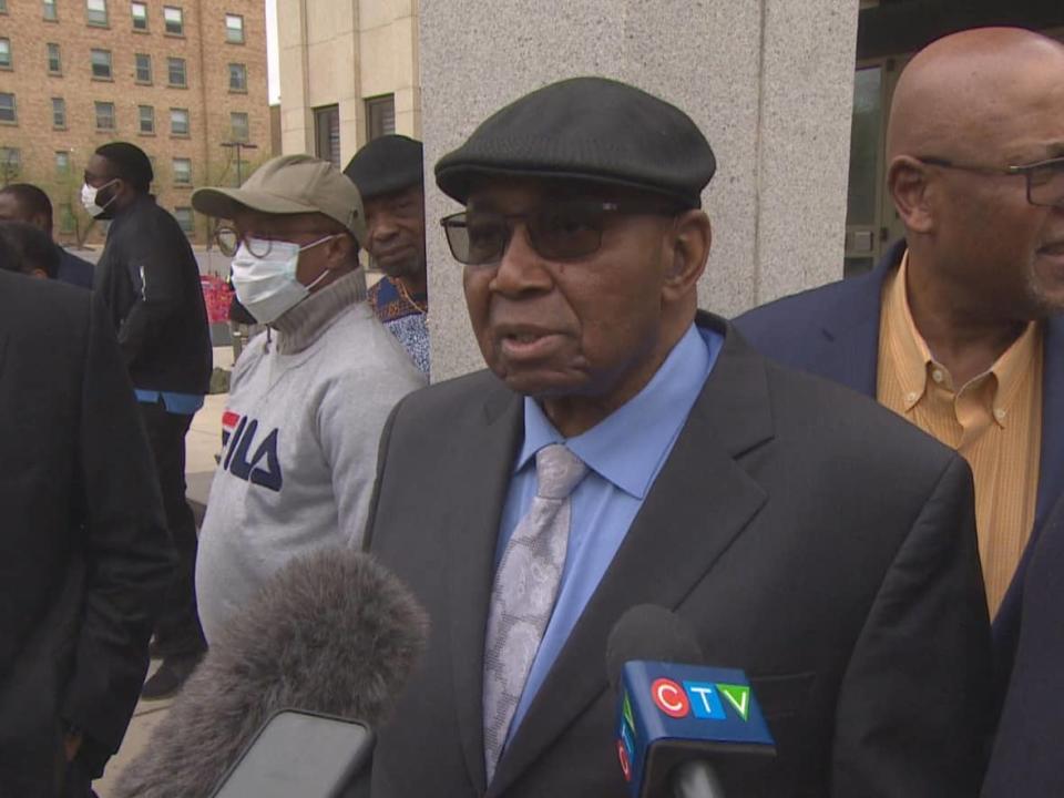 Sylvester Ukabam stands outside the court of Queens bench surrounded by family after being found not guilty of sexually assaulting five patients.  (Richard Agecoutay/CBC - image credit)