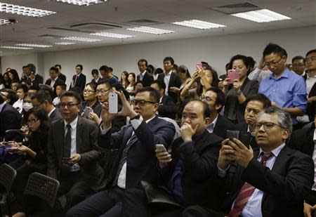 Property sales agents representing buyers record with their smartphones during a draw, organized by a property developer, from more than 1,500 buyers on getting 80 flats of a private residential estate in Hong Kong October 31, 2013. REUTERS/Bobby Yip