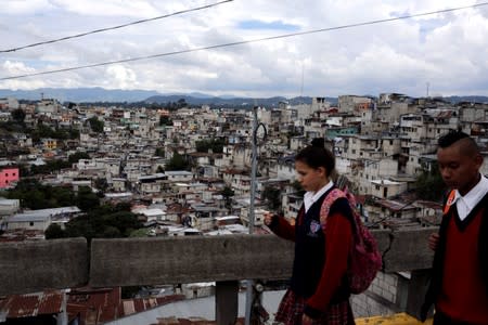 Children walk past La Limonada neighbourhood settlement ahead of Sunday's presidential election in Guatemala City