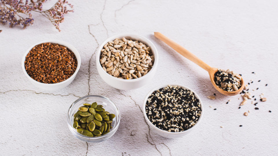 A marble counter with bowls of flax, sesame, pumpkin and sunflower seeds used for seed cycling