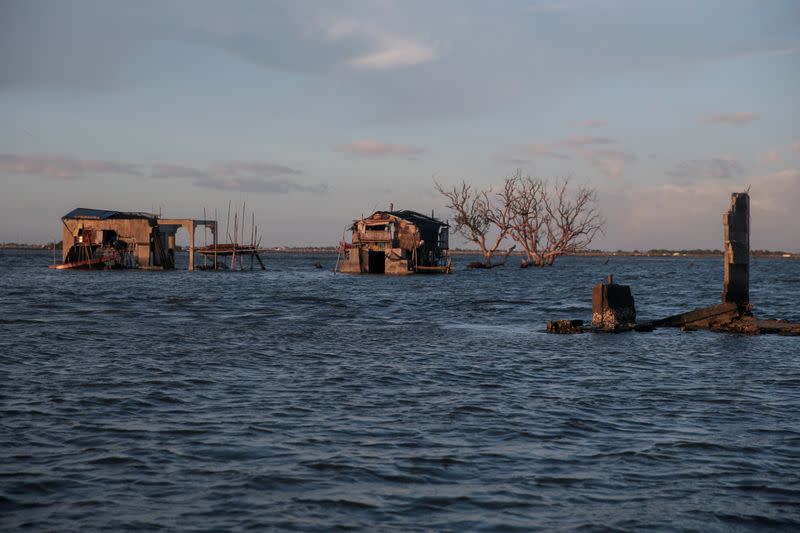 The Wider Image: Rising seas threaten early end for sinking village in Philippines