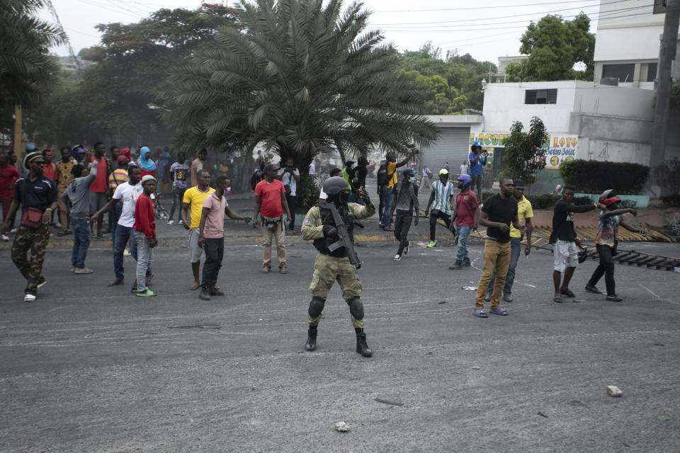 Police attempt to secure an area past a roadblock set up by taxi drivers protesting fuel shortages, in Port-au-Prince, Haiti, Thursday, July 14, 2022. (AP Photo/Odelyn Joseph)