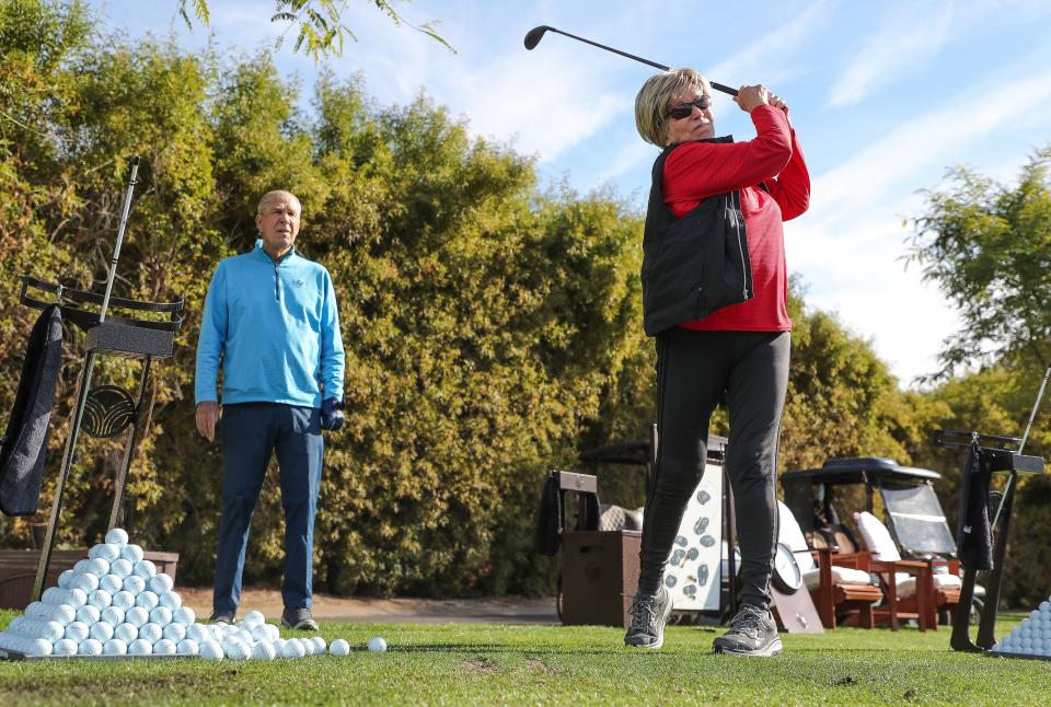 Visually impaired golfer Linda Port hits balls with the help of her husband Fred as the two practiced at The Vintage Club in Indian Wells, Calif., Dec. 16, 2022.