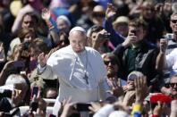 Pope Francis waves as he leads the Easter Mass in Saint Peter's Square at the Vatican April 20, 2014. REUTERS/Tony Gentile