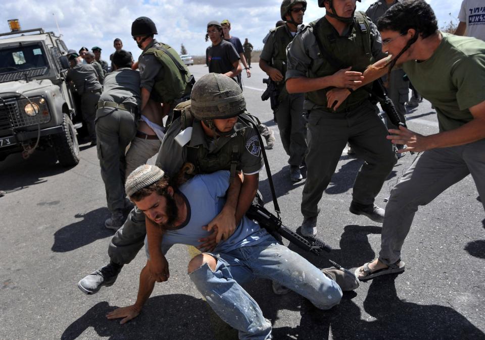 <span>Jewish settlers clash with Israeli border policemen near the illegal outpost of Havat Gilad, west of the occupied West Bank city of Nablus, after police tried to confiscate a truck containing material to build a new house on September 13, 2009</span><div><span>YEHUDA RAIZNER</span><span>AFP</span></div>