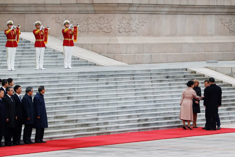 French President Emmanuel Macron and his wife Brigitte Macron attend a welcome ceremony with Chinese President Xi Jinping and his wife Peng Liyuan outside the Great Hall of the People in Beijing