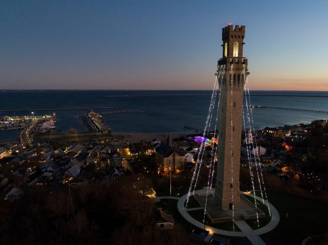 The Pilgrim Monument twinkles in the twilight looking out toward Cape Cod Bay after its annual lighting for the holiday season in 2022.