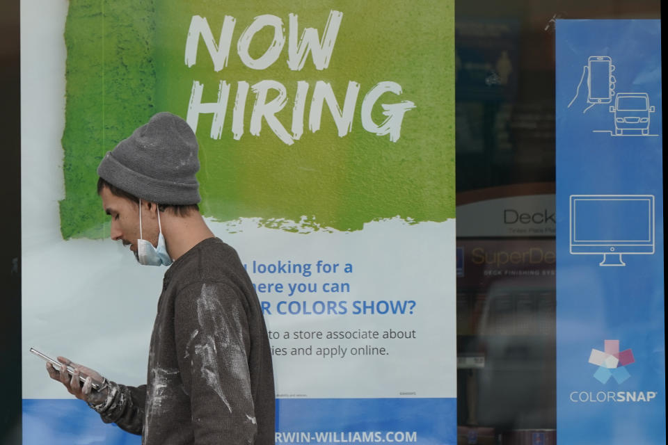 A man walks past a "Now Hiring" sign on a window at Sherwin Williams store, Friday, Feb. 26, 2021, in Woodmere Village, Ohio. Massive fraud in the nation's unemployment system is raising alarms even as President Joe Biden and Congress prepare to pour hundreds of billions more into expanded benefits for those left jobless by the coronavirus pandemic. (AP Photo/Tony Dejak)