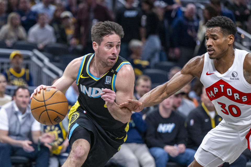 Indiana Pacers guard T.J. McConnell drives the ball along the baseline while defended by Toronto Raptors guard Ochai Agbaji (30) during the first half of an NBA basketball game in Indianapolis, Monday, Feb. 26, 2024. (AP Photo/Doug McSchooler)