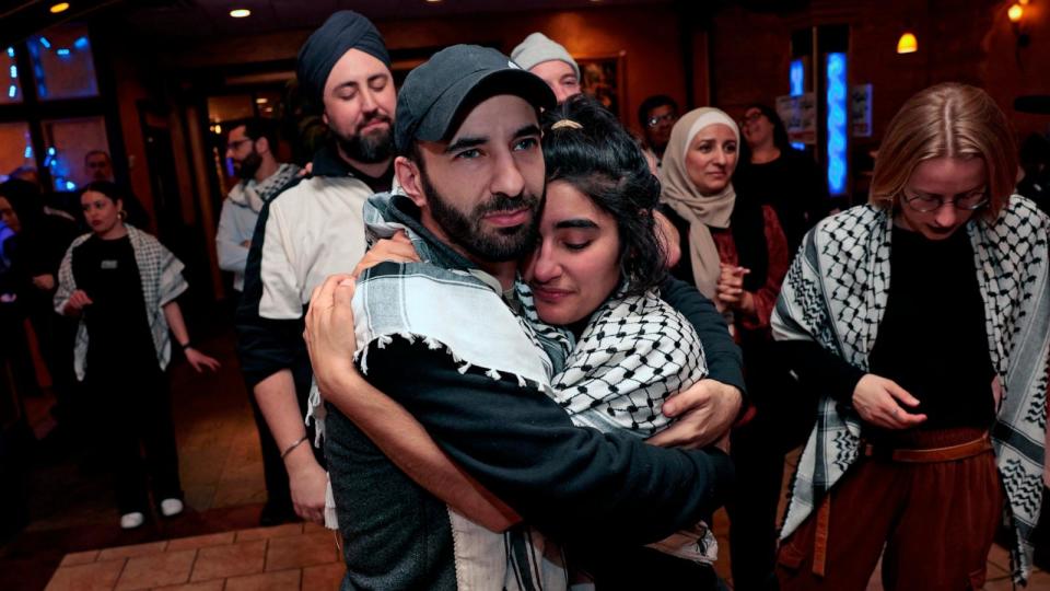 PHOTO: People hug at the People hug at the Listen to Michigan watch party, a group who asked voters to vote uncommitted instead of for President Joe Biden in Michigan's primary election, in Dearborn, Mi., Feb. 27, 2024.  (Jeff Kowalsky/AFP via Getty Images)