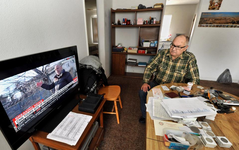 Vlad Brodsky, who moved to Springfield from Ukraine in 1994, watches news reports on Ukraine from his home on Wednesday. [Thomas J. Turney/The State Journal-Register]