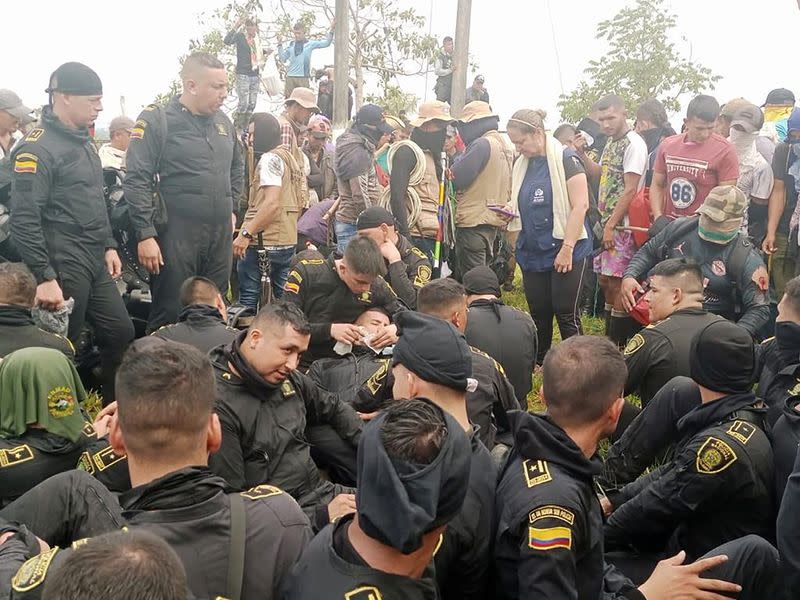 Policías sentados permanecen retenidos por campesinos e indígenas que exigen que la petrolera Emerald Energy construya carreteras, mientras funcionarios de la Defensoría del Pueblo tratan de mediar, en San Vicente del Caguán