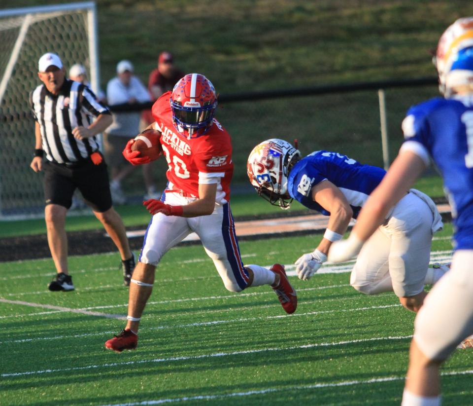 Licking Valley's Jacob Wheeler attempts to elude John Glenn's Cameron Barnhouse at New Lexington's Jim Rockwell Stadium on Friday.