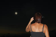 In this photo provided by Tourism Queensland, a woman watches a total solar eclipse at Lakeland in Queensland state, Australia, Wednesday, Nov. 14, 2012. Starting just after dawn, the eclipse cast its 150-kilometer (95-mile) shadow in Australia's Northern Territory, crossed the northeast tip of the country and was swooping east across the South Pacific, where no islands are in its direct path. (AP Photo/Tourism Queensland, David Barker) EDITORIAL USE ONLY