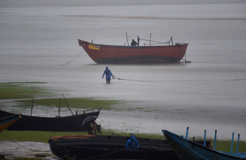 Fishermen tie their boats along the shore before Cyclone Amphan makes its landfall, in the Baleswar district
