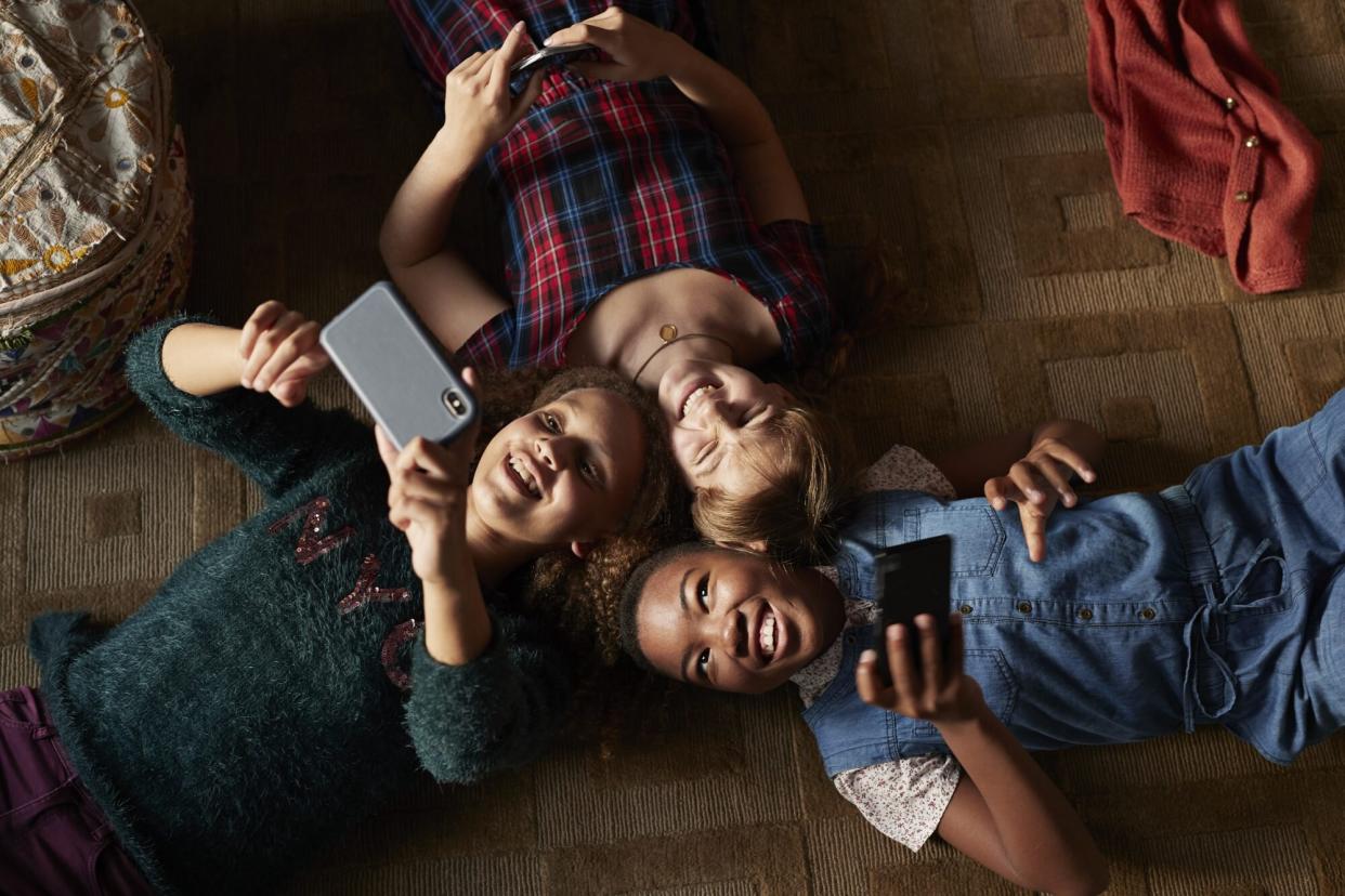 3 preteen girls with smartphones