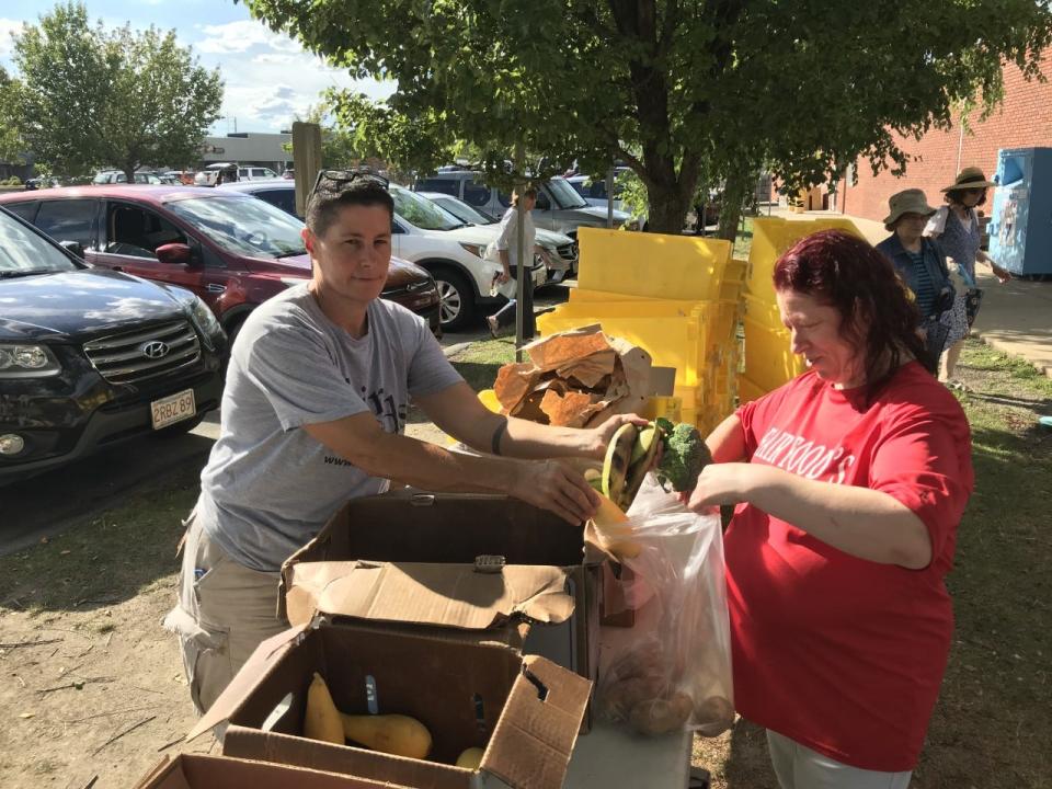 Fair Foods volunteers Kate McDermott, (left) and Susanne Morin prepare bags of fruit and vegetables for people in need to receive outside Old Colony YMCA in Taunton