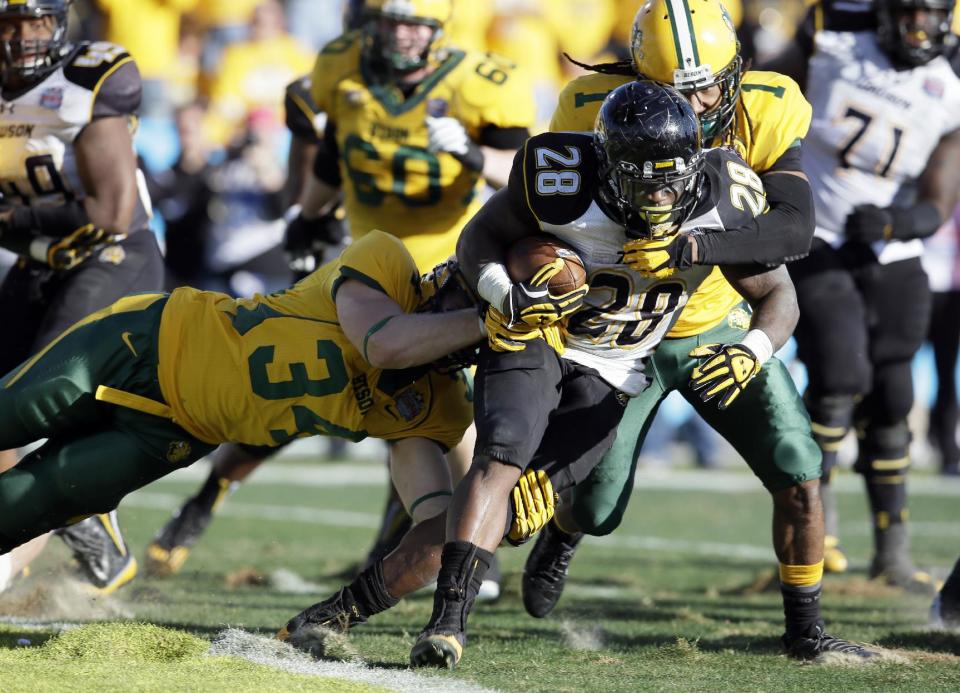 Towson running back Terrance West (28) fights his way out of the end zone avoiding a safety as North Dakota State's Grant Olson (34) and Marcus Williams (1) make the stop in the second half of the FCS championship NCAA college football game, Saturday, Jan. 4, 2014, in Frisco, Texas. NDSU won 35-7. (AP Photo/Tony Gutierrez)
