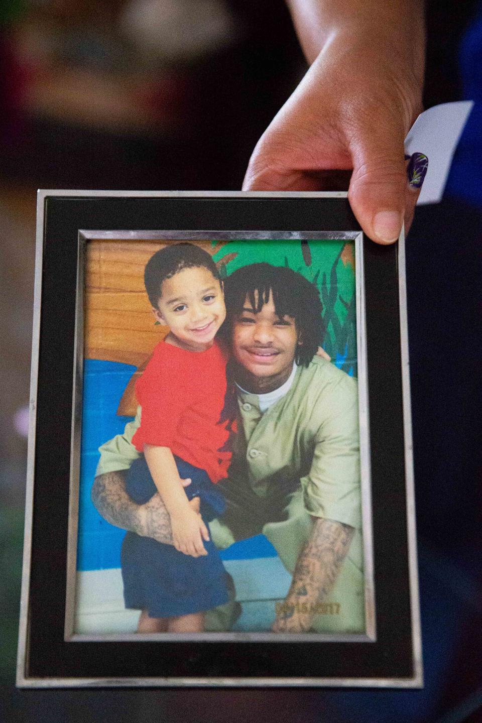 Nakia Dalton holds up a framed picture of her son, Deante Dalton, right, and his now 10-year-old son, Jaide Jones, on Wednesday, June 12, 2024, at Nakia's home in Elkhart.