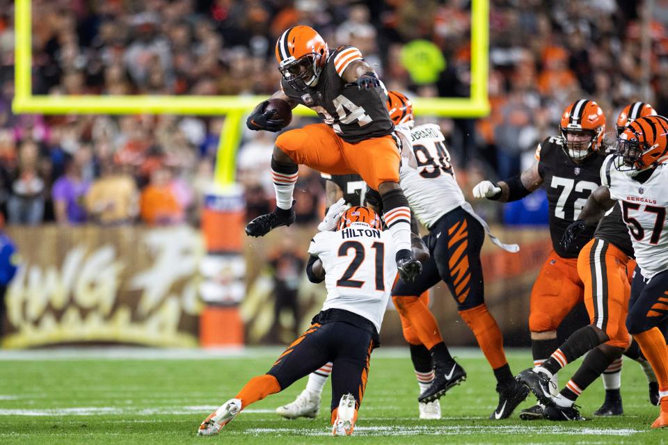 Cleveland Browns running back Nick Chubb (24) leaps over Cincinnati Bengals cornerback Mike Hilton.