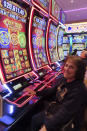 Judy Hozalski plays a slot machine at the Hard Rock casino in Atlantic City, N.J. on Feb. 2, 2024. Figures released on Friday, Feb. 16, from state gambling regulators show the total amount won by Atlantic City's nine casinos, the three horse tracks that take sports bets, and their online partners was more than $559 million in January, up 28% from a year earlier. But much of that was powered by a record-setting month of internet gambling ($183 million, up nearly 20% from a year ago) and sports betting (nearly $171 million, up more than 136%). (AP Photo/Wayne Parry)