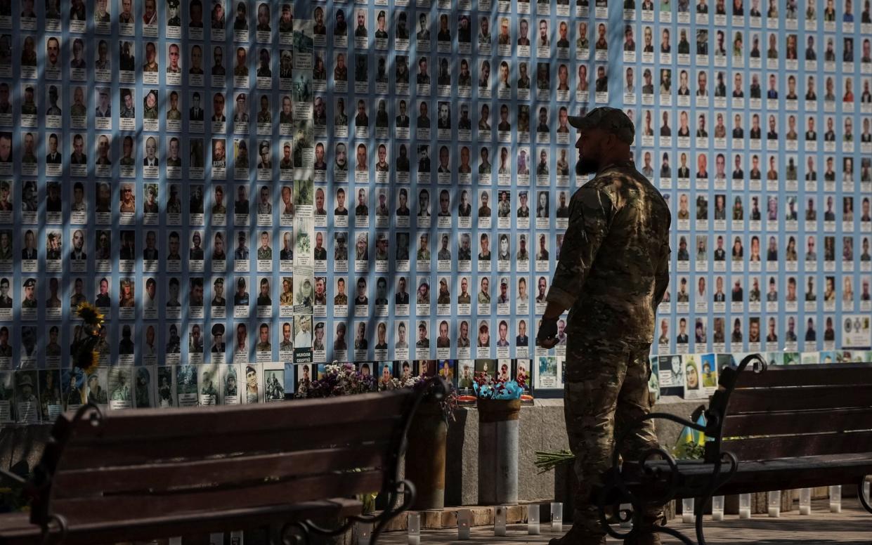 A Ukrainian serviceman visits the Memory Wall of Fallen Defenders of Ukraine in Kyiv