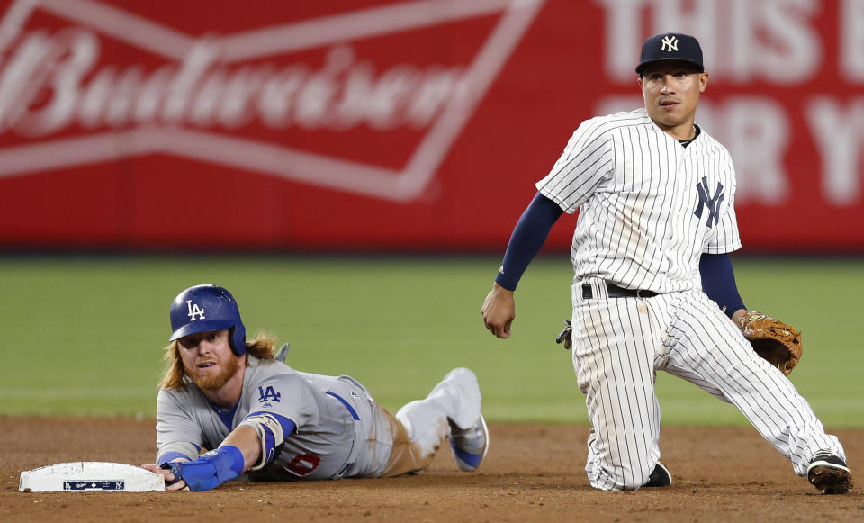 Los Angeles Dodgers' Justin Turner left, and New York Yankees shortstop Ronald Torreyes look toward first after Turner was forced out on a ball hit by Corey Seager, who was safe at first during the sixth inning of a baseball game in New York, Tuesday, Sept. 13, 2016. (AP Photo/Kathy Willens)