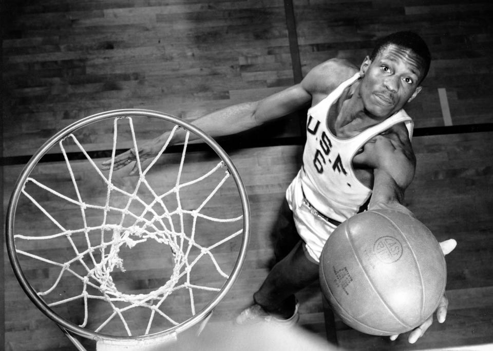 Bill Russell, member of the University of San Francisco basketball team, shows how he scores baskets on Feb. 23, 1956. The 6-foot, 10-inch center, ranked one of the best, has helped his team win 20 straight games during the current season. (AP Photo)