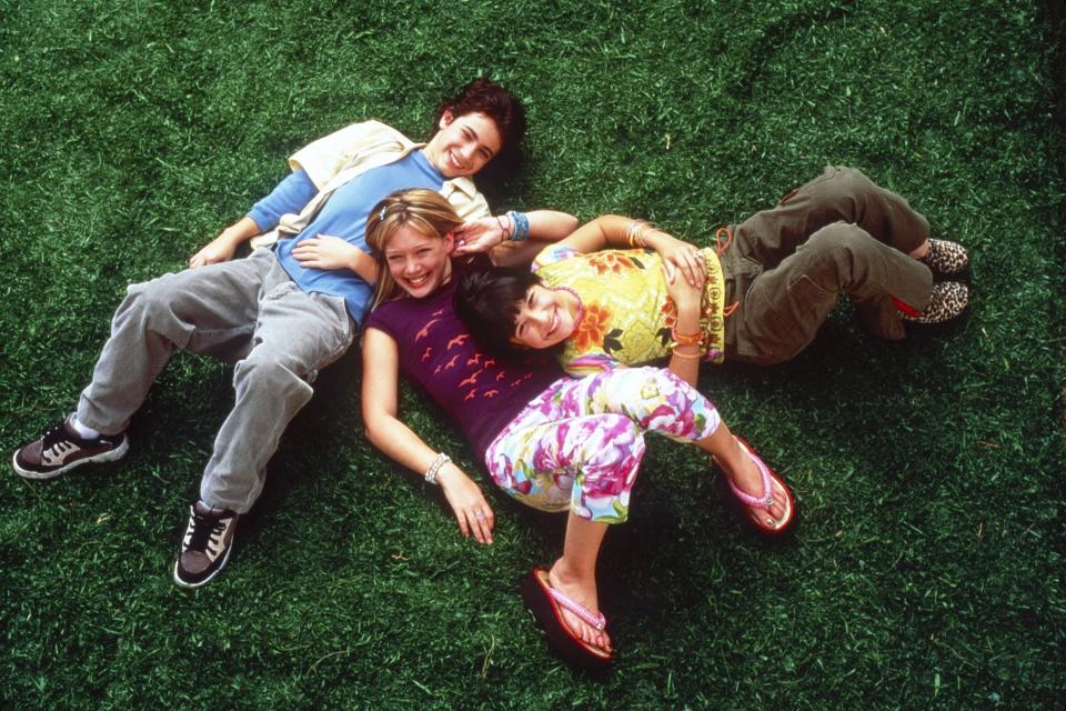 Adam Lamberg, Hilary Duff, and Lalaine lie on the grass