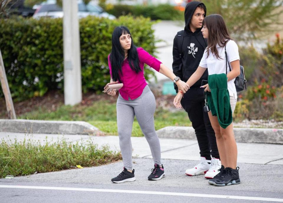 Oliday Gomez holds the hand of her daughter, Mariam Zamora, 14, a freshman, as they cross the street with her brother, Bryan, 16, a sophomore, to arrive at Carol City Senior High School for the first day of classes on Thursday, Aug. 15, 2023, in Miami Gardens, Fla. “I’m nervous but my best friend is here, so it’s fine,” Mariam said.