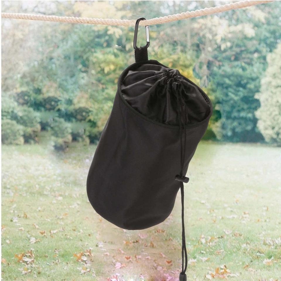 veamor clothespin bag a black cylindrical bag hanging from a clothesline