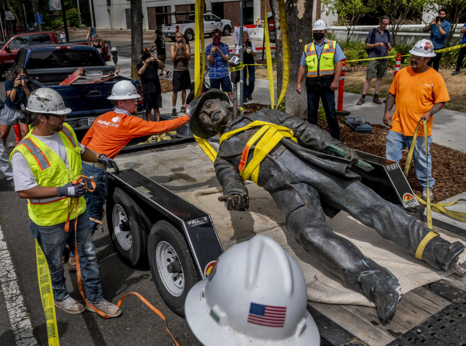 Workers remove a statue of John Sutter, a Swiss settler who built the first European settlement on the site of the city of Sacramento, outside Sutter hospital in midtown on Monday, June 15, 2020. Some historical accounts describe Sutter as using Native Americans as slaves and raping Native American girls as young as age 12. (Daniel Kim/The Sacramento Bee via AP)