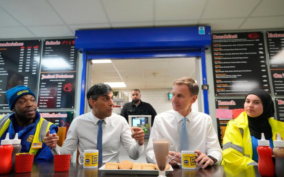 Prime Minister Rishi Sunak and Chancellor of the Exchequer Jeremy Hunt meet staff during a visit to a builders merchant in south east London