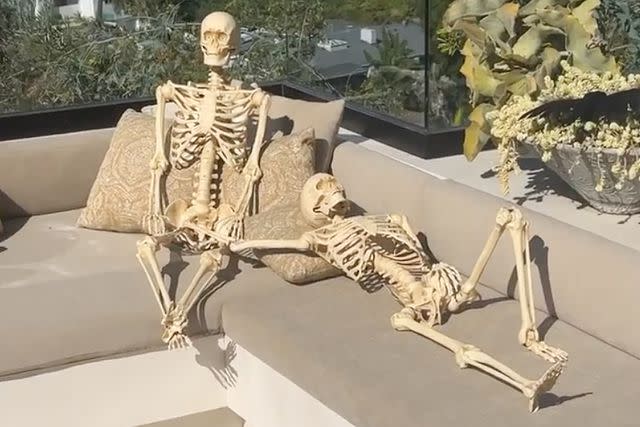 <p>Chrissy Teigen/Instagram</p> Two skeletons soak up the sun beside Teigen and Legend's pool.