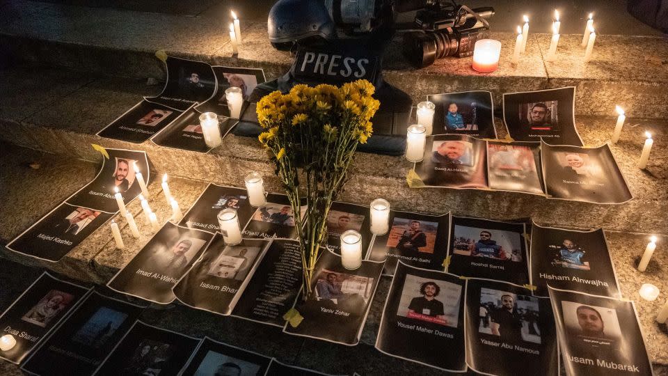 Flowers and candles are placed among pictures of journalists at a vigil in lower Manhattan on November 6, 2023, in New York City. The vigil is held to remember and celebrate the lives of journalists killed in recent fighting in Israel, Gaza and Lebanon. - Spencer Platt/Getty Images