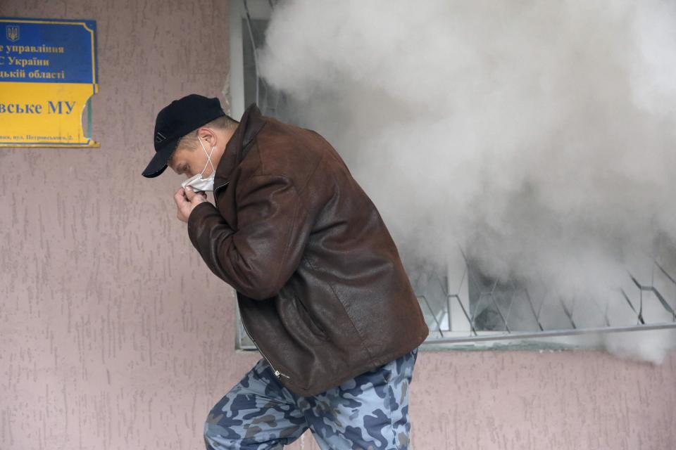 A pro-Russian man runs during the mass storming of a police station in the eastern Ukrainian town of Horlivka on Monday, April 14, 2014. Several government buildings has fallen to mobs of Moscow loyalists in recent days as unrest spreads across the east of the country. (AP Photo/Efrem Lukatsky)