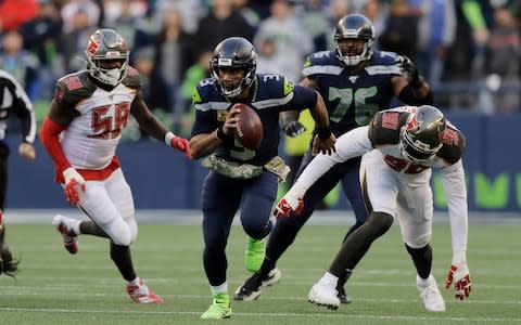 Seattle Seahawks quarterback Russell Wilson (3) scrambles away from Tampa Bay Buccaneers defensive end Jason Pierre-Paul (90) during overtime of an NFL football game, Sunday, Nov. 3, 2019, in Seattle - Credit: AP