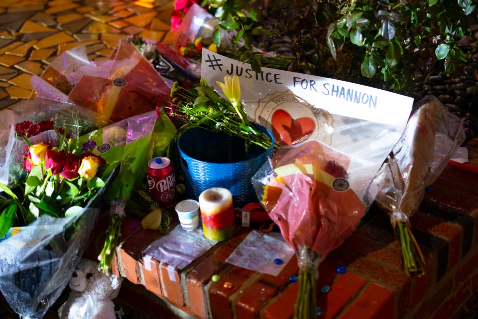 Flowers and other Items left outside the Cookie Cottage are pictured during a candlelight vigil for Shannon Hanchett on Monday in Norman.