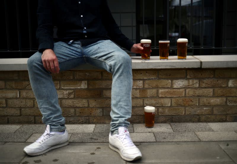 FILE PHOTO: Customer sits next to freshly poured pints of beer in Hackney, London