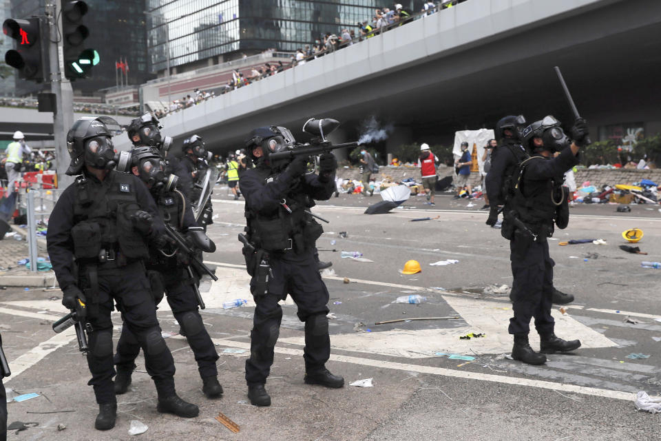 FILE - In this file photo taken Wednesday, June 12, 2019, a policeman fires with a pepper ball gun towards protesters near the Legislative Council in Hong Kong. Hong Kong police have resorted to harsher-than-usual tactics to suppress protesters this week in the city’s most violent turmoil in decades. Police fired rubber bullets and beanbag rounds at the crowds, weapons that have not been widely used in recent history. (AP Photo/Kin Cheung, File)