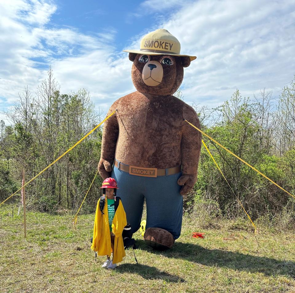 A Girl Scout poses with Smokey Bear during forestry event.